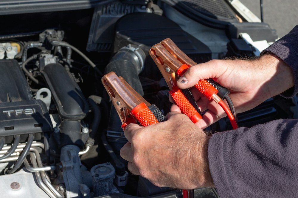 Pinzas de prueba conectadas a la batería del auto